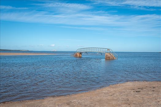 When the tide comes surging into shore, what should be an easy path to the beach becomes suddenly impassable. At high tide, the water swallows the land around the bridge, making it look as though it’s stranded in the middle of a sea.